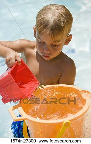Boy filling water in bucket View Large Photo Image Stock Image - Boy filling water in bucket. Fotosearch