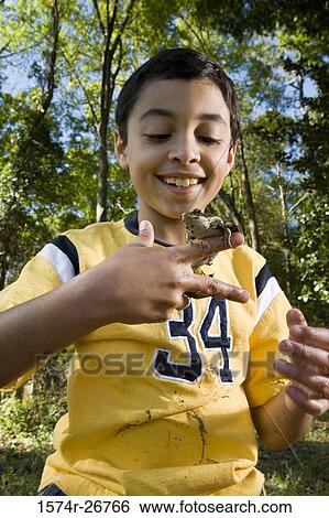 Boy holding a frog on his fingers at forest View Large Photo Image Stock Photograph - Boy holding a frog on his fingers at forest. Fotosearch