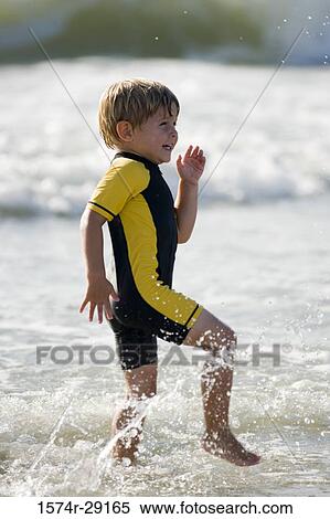 Boy playing in water at the beach View Large Photo Image Stock Photography - Boy playing in water at the beach. Fotosearch