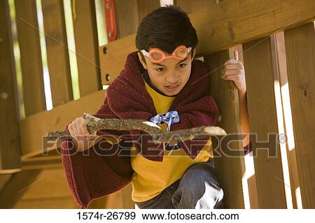 Boy playing with a stick by planks View Large Photo Image Stock Photo - Boy playing with a stick by planks. Fotosearch
