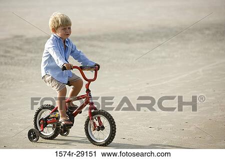 Boy riding cycle at the beach View Large Photo Image Stock Image - Boy riding cycle at the beach. Fotosearch