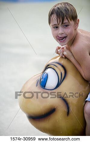 Boy sitting on a tortoise sculpture and sticking out tongue View Large Photo Image Stock Photo - Boy sitting on a tortoise sculpture and sticking out tongue. Fotosearch