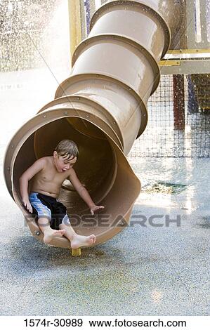Stock Photo - Boy sliding in tunnel slide. Fotosearch