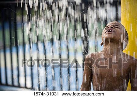 Boy standing under a shower View Large Photo Image Stock Image - Boy standing under a shower. Fotosearch