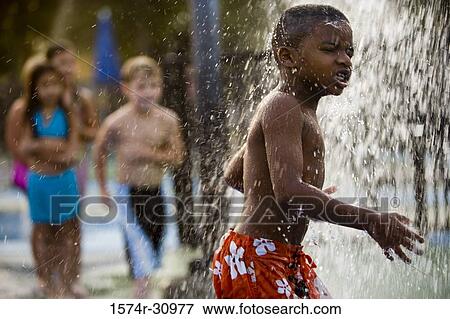 Boy standing under a shower View Large Photo Image Stock Photo - Boy standing under a shower. Fotosearch
