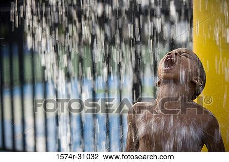 Boy standing under a shower with mouth open View Large Photo Image Stock Image - Boy standing under a shower with mouth open. Fotosearch