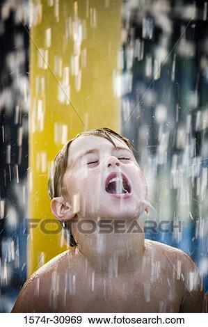 Boy standing under a shower with mouth open View Large Photo Image Stock Photo - Boy standing under a shower with mouth open. Fotosearch