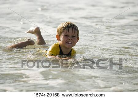 Boy swimming in water at the beach View Large Photo Image Stock Photo - Boy swimming in water at the beach. Fotosearch