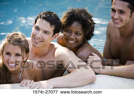 Boyfriends with their girlfriends smiling in swimming pool View Large Photo Image Stock Photo - Boyfriends with their girlfriends smiling in swimming pool. Fotosearch