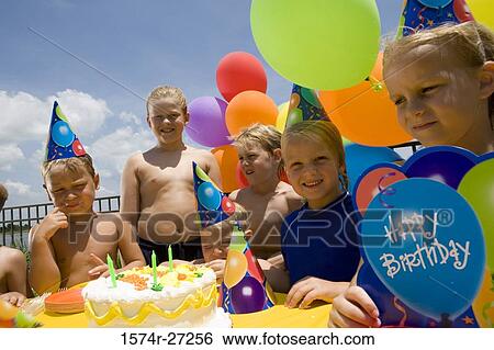 Stock Photograph - Boys and girls celebrating birthday party. Fotosearch