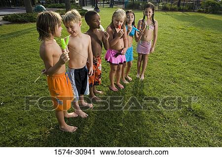 Boys and girls standing together and eating flavored ice View Large Photo Image Stock Image - Boys and girls standing together and eating flavored ice. Fotosearch