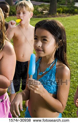 Boys and girls standing together and eating flavored ice View Large Photo Image Stock Photo - Boys and girls standing together and eating flavored ice. Fotosearch
