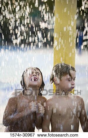 Boys standing together under a shower View Large Photo Image Stock Photo - Boys standing together under a shower. Fotosearch