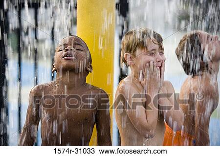 Boys standing under a shower View Large Photo Image Stock Image - Boys standing under a shower. Fotosearch