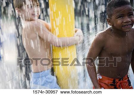 Boys standing under a shower View Large Photo Image Stock Photo - Boys standing under a shower. Fotosearch