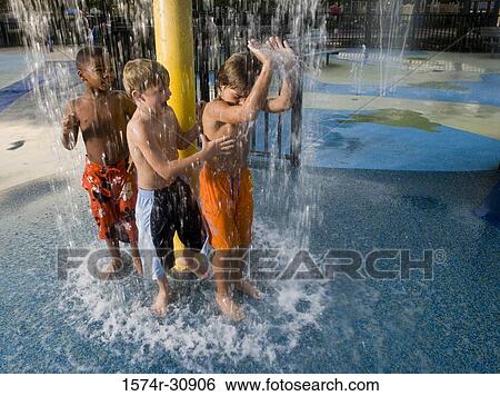 Stock Photograph - Boys standing under a shower. Fotosearch