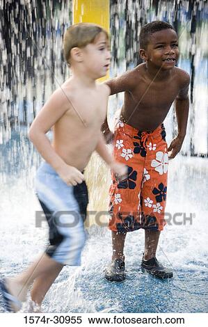 Boys standing under a shower View Large Photo Image Stock Photography - Boys standing under a shower. Fotosearch
