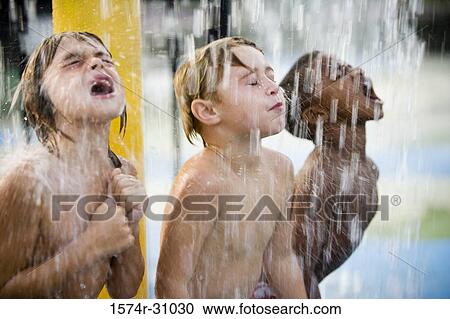 Boys standing under a shower with mouth open View Large Photo Image Stock Image - Boys standing under a shower with mouth open. Fotosearch