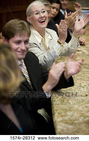 Stock Image - Business people applauding in a meeting at office. Fotosearch