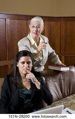 Business people by conference table pointing in an office View Large Photo Image Stock Image - Business people by conference table pointing in an office. Fotosearch