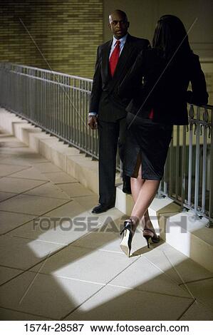Stock Photo - Business People conversing by railing. Fotosearch