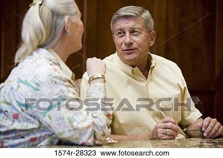 Business people discussing by conference table in an office View Large Photo Image Stock Image - Business people discussing by conference table in an office. Fotosearch
