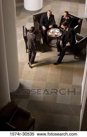 Stock Photography - Business people discussing by table in an office. Fotosearch