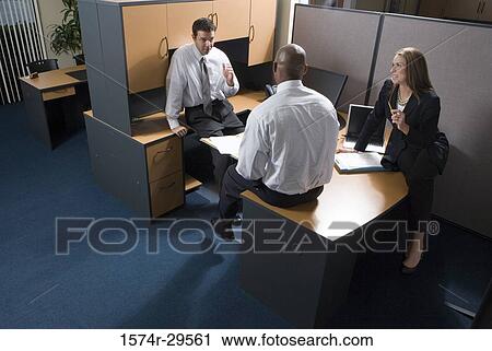 Stock Image - Business people discussing in an office. Fotosearch