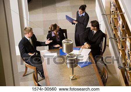 Stock Image - Business people discussing in an office. Fotosearch