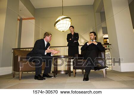 Stock Image - Business people discussing in an office. Fotosearch