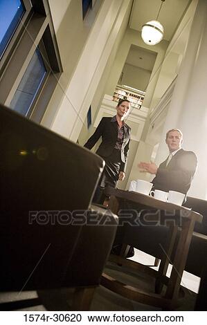 Stock Image - Business people discussing in an office. Fotosearch