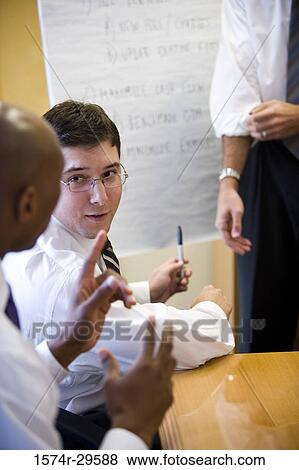Stock Photo - Business people discussing in an office. Fotosearch