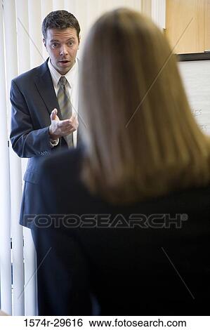 Business people discussing in an office View Large Photo Image Stock Photograph - Business people discussing in an office. Fotosearch