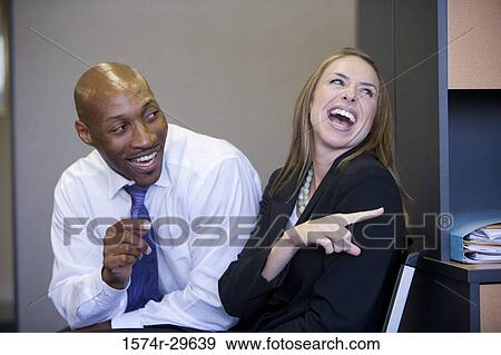 Stock Photo - Business people sitting and smiling in an office. Fotosearch