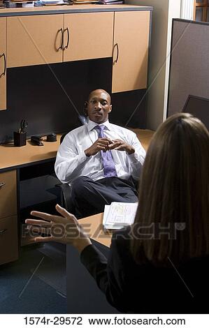 Stock Image - Business people sitting in an office. Fotosearch