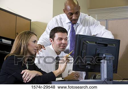 Stock Photo - Business people using computer in an office. Fotosearch