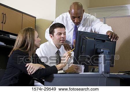 Business people using computer in an office View Large Photo Image Stock Photo - Business people using computer in an office. Fotosearch