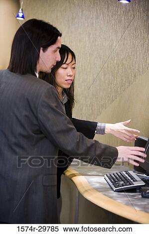 Businessman and a businesswoman pointing in an office View Large Photo Image Stock Photography - Businessman and a businesswoman pointing in an office. Fotosearch