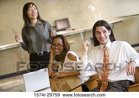 Businessman and businesswomen sitting in an office View Large Photo Image Stock Photo - Businessman and businesswomen sitting in an office. Fotosearch