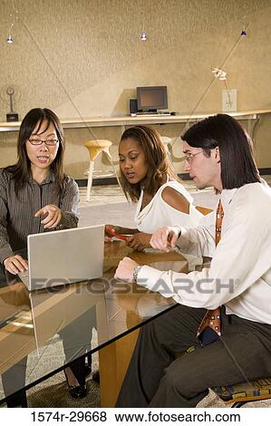 Businessman and businesswomen discussing in an office View Large Photo Image Stock Photo - Businessman and businesswomen discussing in an office. Fotosearch