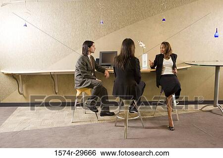 Businessman and businesswomen discussing in the office View Large Photo Image Stock Photograph - Businessman and businesswomen discussing in the office. Fotosearch