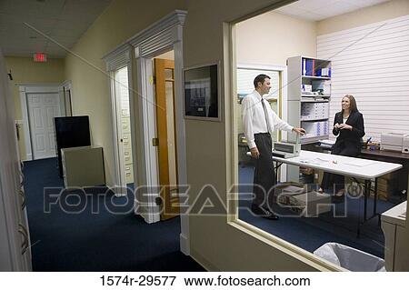 Businessman and woman smiling in office cabin View Large Photo Image Stock Photo - Businessman and woman smiling in office cabin. Fotosearch