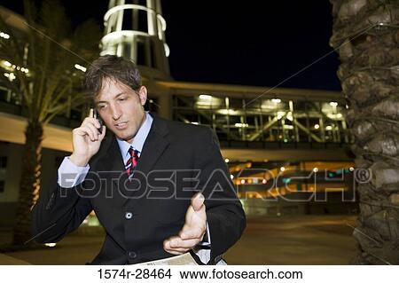 Businessman communicating on cellphone and gesturing View Large Photo Image Picture - Businessman communicating on cellphone and gesturing. Fotosearch