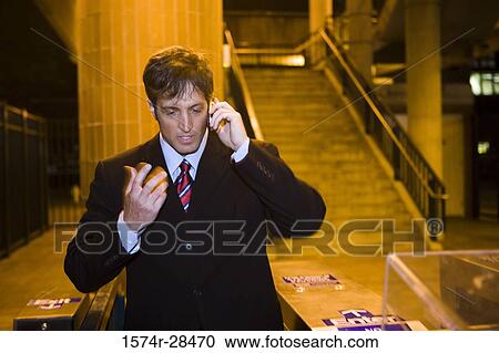 Stock Image - Businessman communicating on cellphone and gesturing. Fotosearch