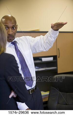 Businessman explaining to a businesswoman in an office View Large Photo Image Stock Photograph - Businessman explaining to a businesswoman in an office. Fotosearch