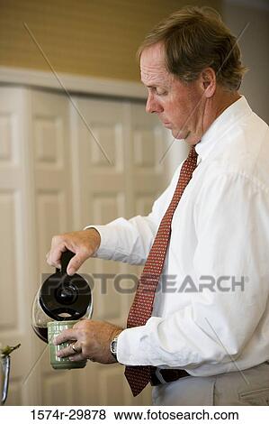 businessman pouring coffee into a coffee mug View Large Photo Image Stock Photo - businessman pouring coffee into a coffee mug. Fotosearch