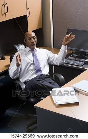 Stock Photo - Businessman sitting by a computer in an office. Fotosearch