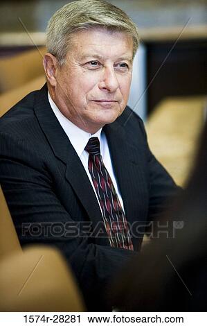Businessman smiling and looking away in an office View Large Photo Image Stock Image - Businessman smiling and looking away in an office. Fotosearch
