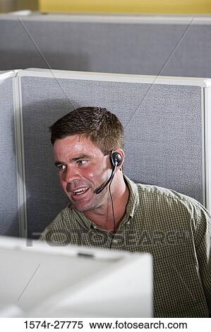 Stock Photography - Businessman using headset in an office. Fotosearch