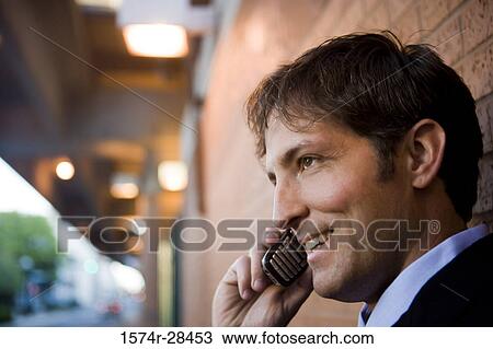 Businessman using mobile phone and smiling View Large Photo Image Stock Image - Businessman using mobile phone and smiling. Fotosearch
